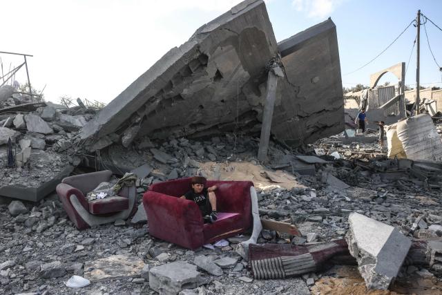 TOPSHOT - A boy sits on an armchair amid the rubble of a building near the site of an Israeli airstrike in Khan Yunis, southern Gaza Strip, on June 7, 2026. Israel and Hamas accuse each other of near-daily violations of the truce meant to halt the war in Gaza, which was triggered by Hamas's October 7, 2023 attack on Israel. At least 961 Palestinians have been killed since the ceasefire took effect on October 10 last year, according to Gaza's health ministry, which operates under Hamas authority and whose figures are considered reliable by the United Nations. The Israeli army has reported five deaths in its ranks during the same period. (Photo by Bashar Taleb / AFP)