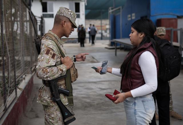 A woman asks a soldier for information at a polling station during the presidential election runoff in San Juan de Lurigancho district, province of Lima, Peru, on June 7, 2026. Peruvians will choose their ninth president in 10 years in a tight runoff election between conservative Keiko Fujimori and leftist Roberto Sanchez, who are trying to woo voters fed up with political chaos and rising crime. (Photo by Anthony Nino de Guzman / AFP)