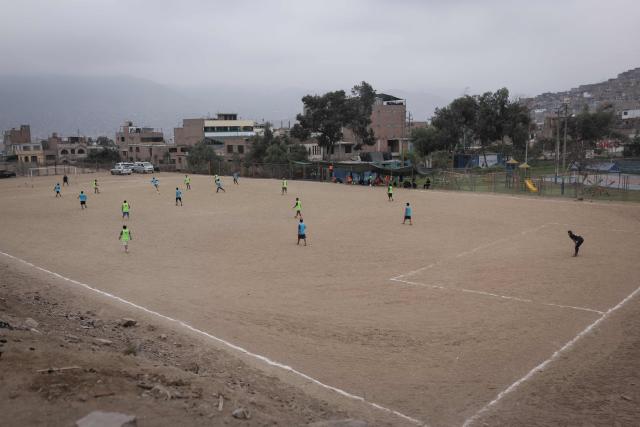 People play a football match during the presidential election runoff in San Juan de Lurigancho district, province of Lima, Peru, on June 7, 2026. Peruvians will choose their ninth president in 10 years in a tight runoff election between conservative Keiko Fujimori and leftist Roberto Sanchez, who are trying to woo voters fed up with political chaos and rising crime. (Photo by Anthony Nino de Guzman / AFP)