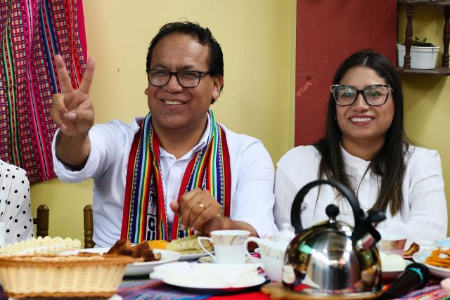 Peru's presidential candidate Roberto Sanchez, for the Juntos por el Peru party, flashes a victory sign next to his wife Claudia Pinazzo during an election-day breakfast in Huaral, Lima department, Peru on June 7, 2026. Peruvians will choose their ninth president in 10 years in a tight runoff election between conservative Keiko Fujimori and leftist Roberto Sanchez, who are trying to woo voters fed up with political chaos and rising crime. (Photo by Connie FRANCE / AFP)
