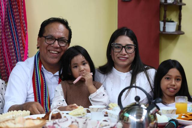 Peru's presidential candidate Roberto Sanchez, for the Juntos por el Peru party, poses with his wife Claudia Pinazzo (2nd R) and their daughters Qorianka (R) and Killa during an election-day breakfast in Huaral, Lima department, Peru on June 7, 2026. Peruvians will choose their ninth president in 10 years in a tight runoff election between conservative Keiko Fujimori and leftist Roberto Sanchez, who are trying to woo voters fed up with political chaos and rising crime. (Photo by Connie FRANCE / AFP)