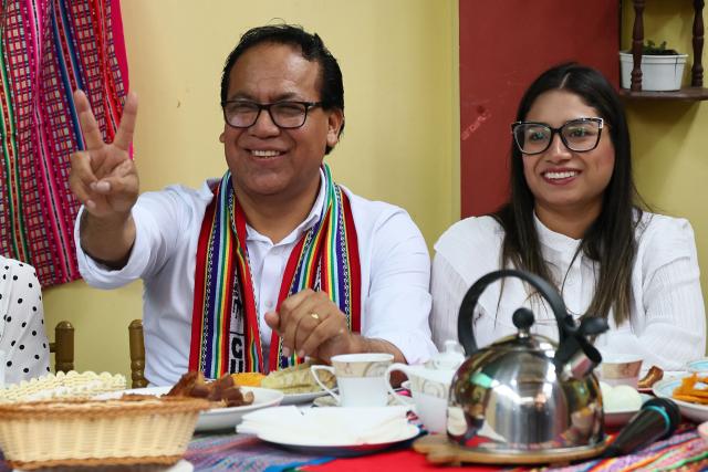 Peru's presidential candidate Roberto Sanchez, for the Juntos por el Peru party, flashes a victory sign next to his wife Claudia Pinazzo during an election-day breakfast in Huaral, Lima department, Peru on June 7, 2026. Peruvians will choose their ninth president in 10 years in a tight runoff election between conservative Keiko Fujimori and leftist Roberto Sanchez, who are trying to woo voters fed up with political chaos and rising crime. (Photo by Connie FRANCE / AFP)