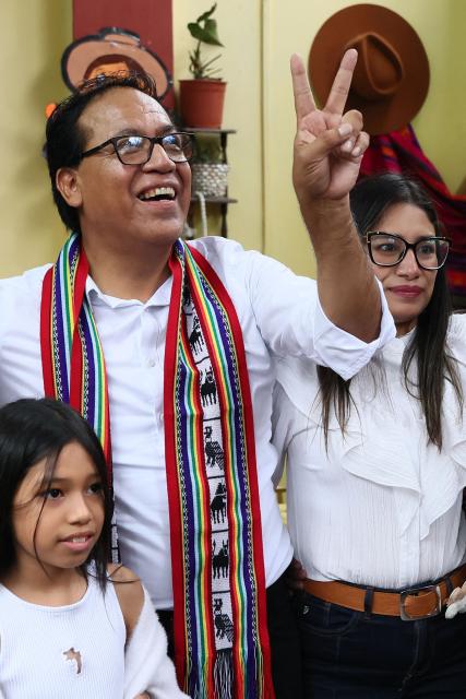Peru's presidential candidate Roberto Sanchez, for the Juntos por el Peru party, flashes a victory sign next to his wife Claudia Pinazzo (R) and their daughter Qorianka during an election-day breakfast in Huaral, Lima department, Peru on June 7, 2026. Peruvians will choose their ninth president in 10 years in a tight runoff election between conservative Keiko Fujimori and leftist Roberto Sanchez, who are trying to woo voters fed up with political chaos and rising crime. (Photo by Connie FRANCE / AFP)