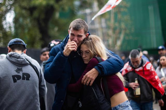Fans react as they wait to pay their respects to the coffin with the remains of Carlos Alberto "Indio" Solari, the iconic Argentine rock musician and former lead singer of Patricio Rey y sus Redonditos de Ricota, at Villa Dominico, Buenos Aires Province, Argentina, on June 7, 2026. The singer died in Parque Leloir, Buenos Aires Province, on June 5 at the age of 77. (Photo by Tomas CUESTA / AFP)