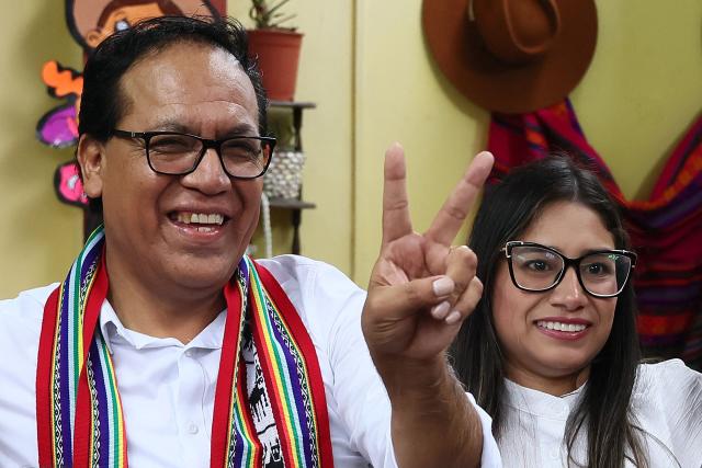 Peru's presidential candidate Roberto Sanchez, for the Juntos por el Peru party, flashes a victory sign next to his wife Claudia Pinazzo during an election-day breakfast in Huaral, Lima department, Peru on June 7, 2026. Peruvians will choose their ninth president in 10 years in a tight runoff election between conservative Keiko Fujimori and leftist Roberto Sanchez, who are trying to woo voters fed up with political chaos and rising crime. (Photo by Connie FRANCE / AFP)