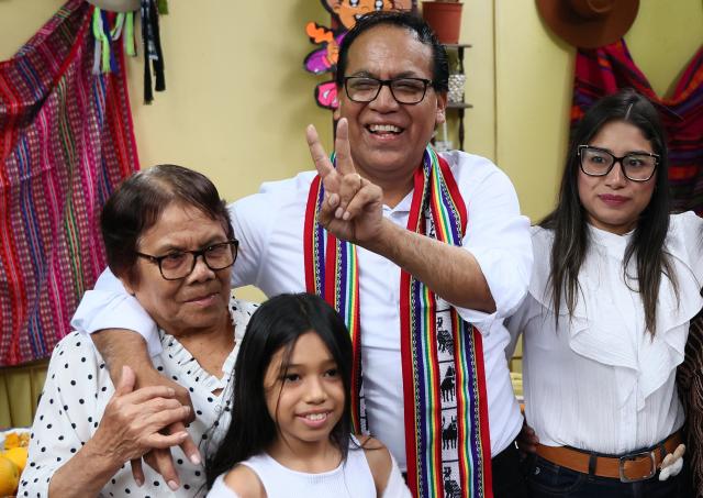 Peru's presidential candidate Roberto Sanchez, for the Juntos por el Peru party, flashes a victory sign next to his wife Claudia Pinazzo (R), their daughter Qorianka and his mother during an election-day breakfast in Huaral, Lima department, Peru on June 7, 2026. Peruvians will choose their ninth president in 10 years in a tight runoff election between conservative Keiko Fujimori and leftist Roberto Sanchez, who are trying to woo voters fed up with political chaos and rising crime. (Photo by Connie FRANCE / AFP)