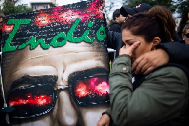 Fans react as they wait to pay their respects to the coffin with the remains of Carlos Alberto "Indio" Solari, the iconic Argentine rock musician and former lead singer of Patricio Rey y sus Redonditos de Ricota, at Villa Dominico, Buenos Aires Province, Argentina, on June 7, 2026. The singer died in Parque Leloir, Buenos Aires Province, on June 5 at the age of 77. (Photo by Tomas CUESTA / AFP)