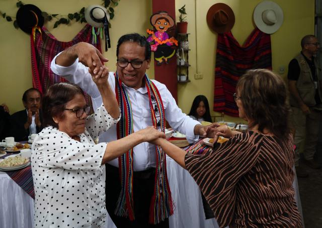 Peru's presidential candidate Roberto Sanchez (C), for the Juntos por el Peru party, dances with his mother (L) and mother-in-law during an election-day breakfast in Huaral, Lima department, Peru on June 7, 2026. Peruvians will choose their ninth president in 10 years in a tight runoff election between conservative Keiko Fujimori and leftist Roberto Sanchez, who are trying to woo voters fed up with political chaos and rising crime. (Photo by Connie FRANCE / AFP)