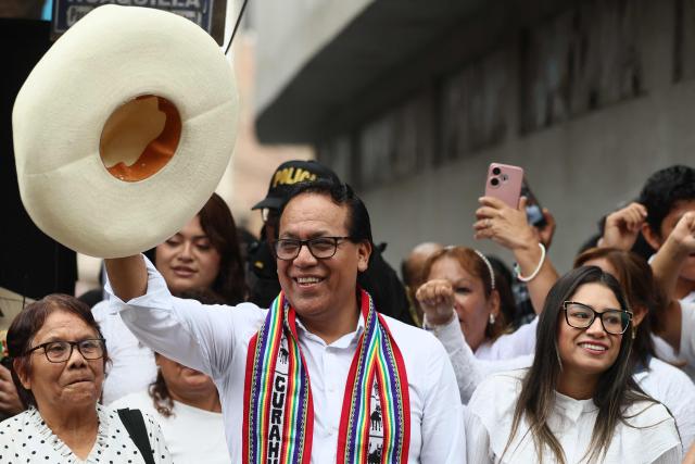 Peru's presidential candidate Roberto Sanchez, for the Juntos por el Peru party, greets supporters next to his wife Claudia Pinazzo (R) and his mother after an election-day breakfast in Huaral, Lima department, Peru on June 7, 2026. Peruvians will choose their ninth president in 10 years in a tight runoff election between conservative Keiko Fujimori and leftist Roberto Sanchez, who are trying to woo voters fed up with political chaos and rising crime. (Photo by Connie FRANCE / AFP)