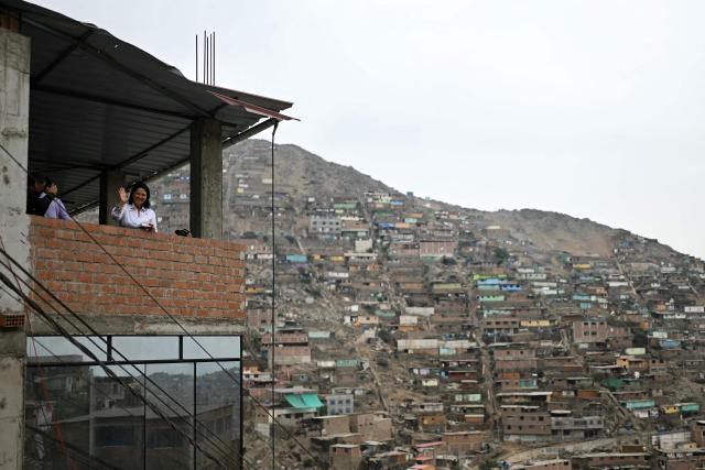 Peru's presidential candidate Keiko Fujimori, for the Fuerza Popular party, waves from the building where she is having an election-day breakfast in San Juan de Lurigancho, northern outskirts of Lima, on June 7, 2026. Peruvians will choose their ninth president in 10 years in a tight runoff election between conservative Keiko Fujimori and leftist Roberto Sanchez, who are trying to woo voters fed up with political chaos and rising crime. (Photo by ERNESTO BENAVIDES / AFP)