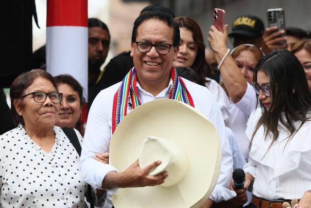 Peru's presidential candidate Roberto Sanchez, for the Juntos por el Peru party, gestures next to his wife Claudia Pinazzo (R) and his mother after an election-day breakfast in Huaral, Lima department, Peru on June 7, 2026. Peruvians will choose their ninth president in 10 years in a tight runoff election between conservative Keiko Fujimori and leftist Roberto Sanchez, who are trying to woo voters fed up with political chaos and rising crime. (Photo by Connie FRANCE / AFP)
