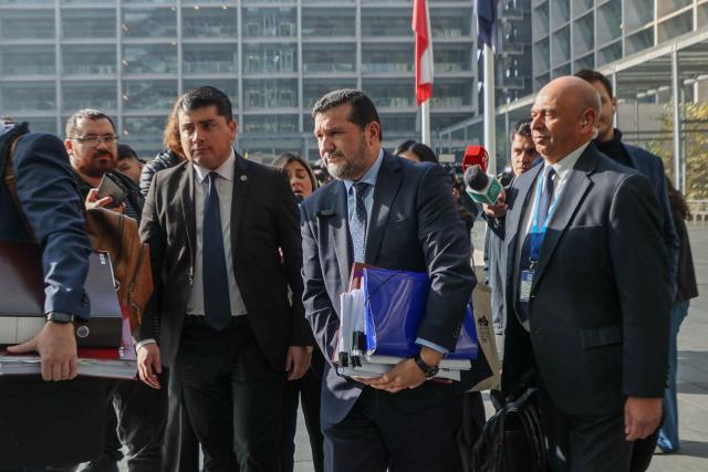 Regional prosecutor Hector Barros (C) arrives at the courthouse for the arraignment of 17 defendants in the Tren de Aragua organized crime case, charged with money laundering, illicit association, extortion, and smuggling, in Santiago on June 7, 2026. (Photo by Raul BRAVO / AFP)