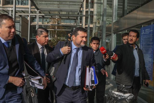 Regional prosecutor Hector Barros (C) arrives at the courthouse for the arraignment of 17 defendants in the Tren de Aragua organized crime case, charged with money laundering, illicit association, extortion, and smuggling, in Santiago on June 7, 2026. (Photo by Raul BRAVO / AFP)