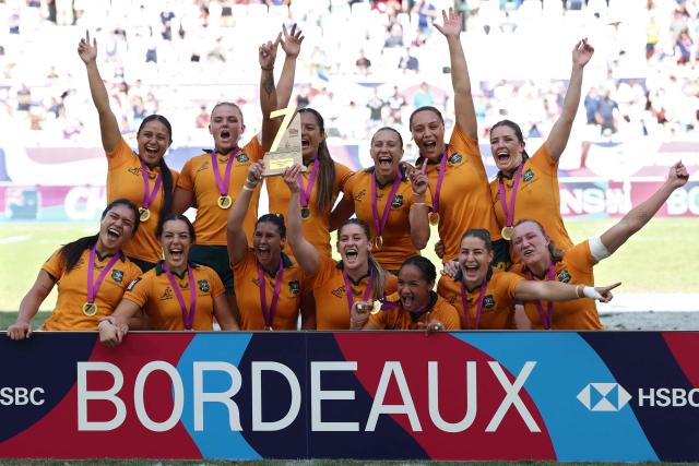 Australia's players celebrate with the trophy at the end of the HSBC SVNS World Championship women's rugby union sevens final match between New Zealand and Australia at the Atlantique Bordeaux Metropole Stadium in Bordeaux, southwestern France, on June 7, 2026. (Photo by ROMAIN PERROCHEAU / AFP)