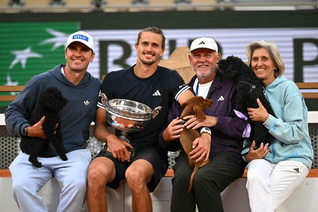 Germany's Alexander Zverev poses with the Coupe des Mousquetaires (Musketeers' Trophy) and his family after winning the men's final singles match against Italy's Flavio Cobolli on day 15 of the French Open tennis tournament on Court Philippe-Chatrier at the Roland-Garros Complex in Paris on June 7, 2026. (Photo by JULIEN DE ROSA / AFP)