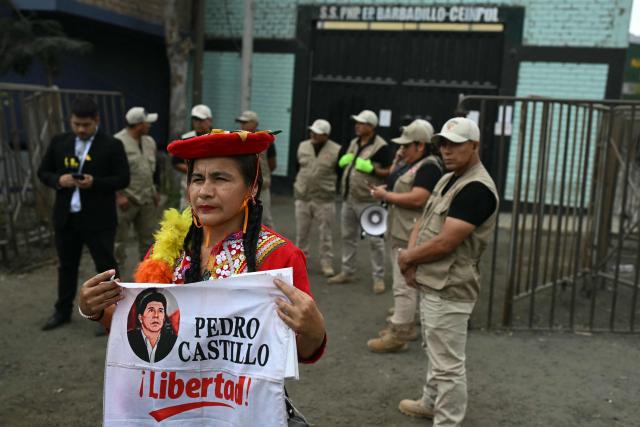 A supporter of former Peruvian president Pedro Castillo and presidential candidate Roberto Sanchez holds a banner calling for Castillo's release outside the Barbadillo prison, where Castillo is being held, in Lima on June 7, 2026, during the presidential runoff election. Peruvians will choose their ninth president in 10 years, in a tight runoff election between conservative Keiko Fujimori and leftist Roberto Sanchez who are trying to woo voters fed up with political chaos and rising crime. (Photo by ERNESTO BENAVIDES / AFP)