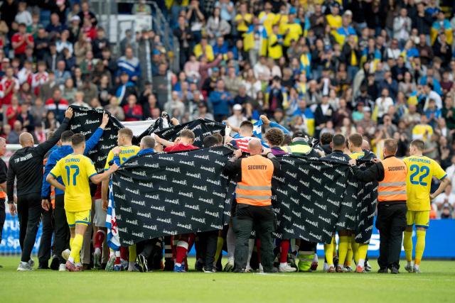 Denmark's and Ukraine's players huddle to accompany Christian Eriksen to a waiting ambulance during the football international friendly match between Denmark and Ukraine at Odense Stadium in Denmark, on June 7, 2026. Christian Eriksen collapsed during Denmark's friendly against Ukraine on June 7, 2026, five years after he suffered a cardiac arrest during the European Championships. (Photo by Bo Amstrup / Ritzau Scanpix / AFP) / Denmark OUT