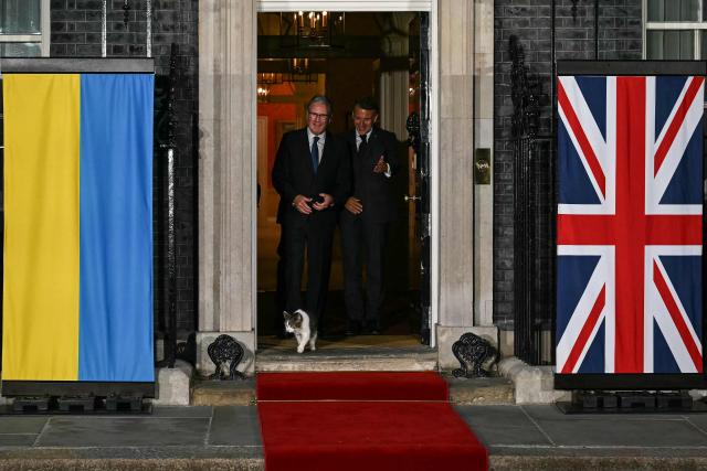 Britain's Prime Minister Keir Starmer (L) and France's President Emmanuel Macron (R) chat on the 10 Downing Street doorstep as 'Larry the Cat' walks outside, after a meeting in central London on June 7, 2026. (Photo by Ben STANSALL / POOL / AFP)