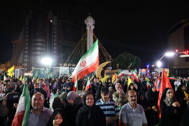 Pro-government Iranian demonstrators wave flags of Iran and Lebanon's Hezbollah movement after Isreali strikes on Beirut's southern suburbs in Tehran on June 7, 2026. Air raid sirens sounded in Israel on Sunday as its military worked to intercept barrages of incoming Iranian missiles for the first time since an April ceasefire took hold in the Middle East war. Iran's powerful Revolutionary Guards called the attack a "warning" after Israel struck Beirut's southern suburbs earlier in the day, threatening wider strikes in the event of repeated aggression. (Photo by ATTA KENARE / AFP) / 