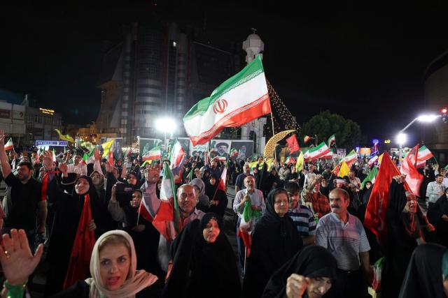 Pro-government Iranian demonstrators wave flags of Iran and Lebanon's Hezbollah movement after Isreali strikes on Beirut's southern suburbs in Tehran on June 7, 2026. Air raid sirens sounded in Israel on Sunday as its military worked to intercept barrages of incoming Iranian missiles for the first time since an April ceasefire took hold in the Middle East war. Iran's powerful Revolutionary Guards called the attack a "warning" after Israel struck Beirut's southern suburbs earlier in the day, threatening wider strikes in the event of repeated aggression. (Photo by ATTA KENARE / AFP) / 
