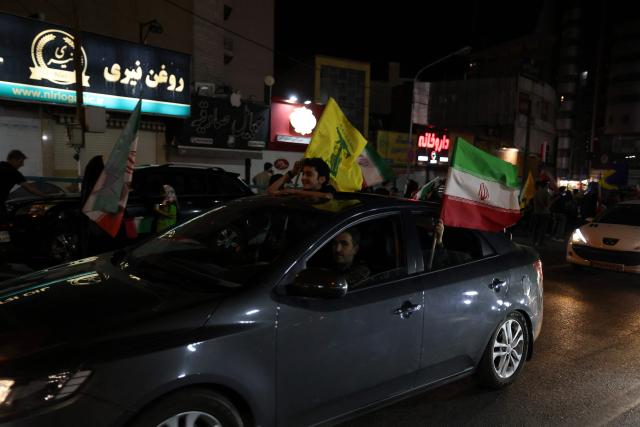 Pro-government Iranian demonstrators wave flags of Iran and Lebanon's Hezbollah movement after Isreali strikes on Beirut's southern suburbs in Tehran on June 7, 2026. Air raid sirens sounded in Israel on Sunday as its military worked to intercept barrages of incoming Iranian missiles for the first time since an April ceasefire took hold in the Middle East war. Iran's powerful Revolutionary Guards called the attack a "warning" after Israel struck Beirut's southern suburbs earlier in the day, threatening wider strikes in the event of repeated aggression. (Photo by ATTA KENARE / AFP) / 