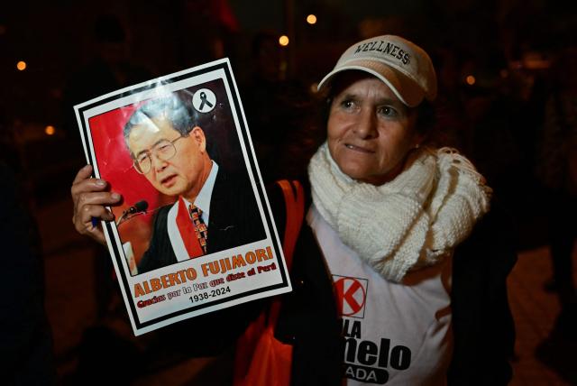 A supporter of Peru's presidential candidate Keiko Fujimori, for the Fuerza Popular party, shows a portrait of former president Alberto Fujimori (1990-2000) during the presidential election runoff in Lima on June 7, 2026. Peruvians will choose their ninth president in 10 years in a tight runoff election between conservative Keiko Fujimori and leftist Roberto Sanchez, who are trying to woo voters fed up with political chaos and rising crime. (Photo by MARTIN BERNETTI / AFP)