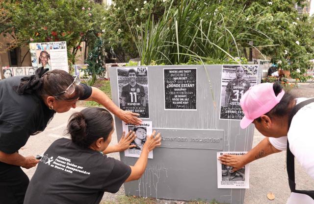 Relatives of missing persons from the collective United Forces for the Disappeared of Nuevo Leon, FUNDENL, paste pictures of their loved ones during a protest called 'Wear the shirt for the disappeared' in Monterrey, Nuevo Leon, Mexico on June 6, 2026. (Photo by Julio Cesar AGUILAR / AFP)