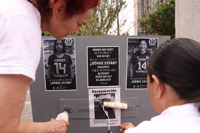 Relatives of missing persons from the collective United Forces for the Disappeared of Nuevo Leon, FUNDENL, paste pictures of their loved ones during a protest called 'Wear the shirt for the disappeared' in Monterrey, Nuevo Leon, Mexico on June 6, 2026. (Photo by Julio Cesar AGUILAR / AFP)