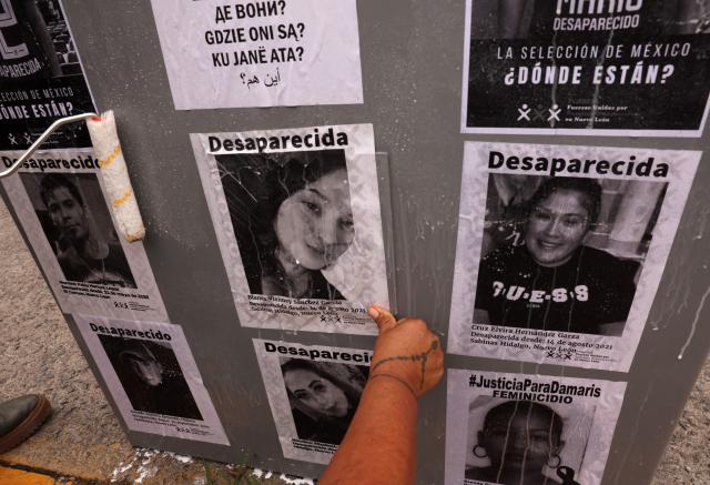 Relatives of missing persons from the collective United Forces for the Disappeared of Nuevo Leon, FUNDENL, paste pictures of their loved ones during a protest called 'Wear the shirt for the disappeared' in Monterrey, Nuevo Leon, Mexico on June 6, 2026. (Photo by Julio Cesar AGUILAR / AFP)