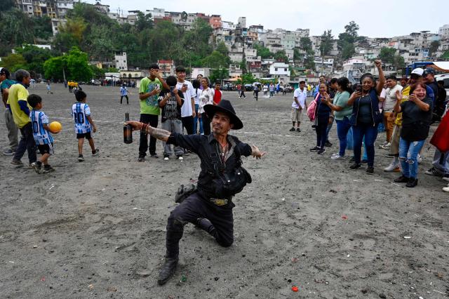 A man dances at the Maracana football pitch in La Limonada neighbourhood in Guatemala City on June 7, 2026. Named after the iconic Maracana Stadium in Brazil, these dirt fields of the same name are a landmark of amateur football in Guatemala City. The Maracana pitch is located in an area that for years was marked by violence, bringing together players and fans from different neighborhoods of the capital every week. (Photo by Johan ORDONEZ / AFP)