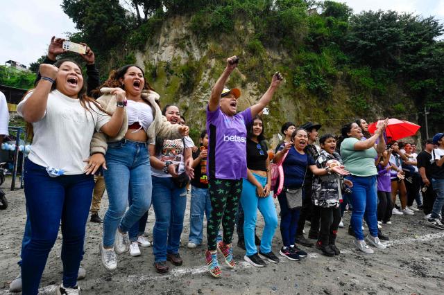 Spectators cheer during an amateur football match at the Maracana pitch in La Limonada neighbourhood in Guatemala City on June 7, 2026. Named after the iconic Maracana Stadium in Brazil, these dirt fields of the same name are a landmark of amateur football in Guatemala City. The Maracana pitch is located in an area that for years was marked by violence, bringing together players and fans from different neighborhoods of the capital every week. (Photo by Johan ORDONEZ / AFP)