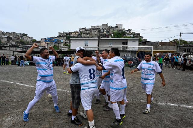 "Sportin" amateur football team players celebrate during a match at the Maracana pitch in La Limonada neighbourhood in Guatemala City on June 7, 2026. Named after the iconic Maracana Stadium in Brazil, these dirt fields of the same name are a landmark of amateur football in Guatemala City. The Maracana pitch is located in an area that for years was marked by violence, bringing together players and fans from different neighborhoods of the capital every week. (Photo by Johan ORDONEZ / AFP)