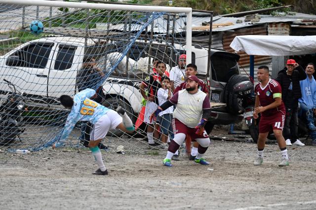 An amateur football player scores a goal at the Maracana pitch in La Limonada neighbourhood in Guatemala City on June 7, 2026. Named after the iconic Maracana Stadium in Brazil, these dirt fields of the same name are a landmark of amateur football in Guatemala City. The Maracana pitch is located in an area that for years was marked by violence, bringing together players and fans from different neighborhoods of the capital every week. (Photo by Johan ORDONEZ / AFP)