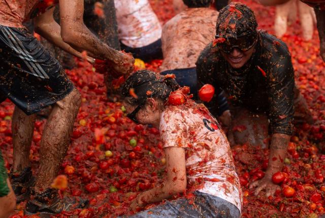People throw tomatoes during the 16th Tomato Fight Festival known as "Tomatina" in Sutamarchan, Boyaca department, Colombia on June 7, 2026. (Photo by ESTEBAN VEGA LA-ROTTA / AFP)