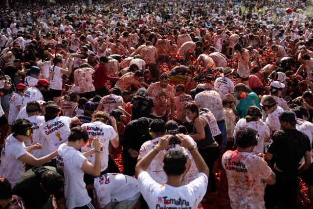 People throw tomatoes during the 16th Tomato Fight Festival known as "Tomatina" in Sutamarchan, Boyaca department, Colombia on June 7, 2026. (Photo by ESTEBAN VEGA LA-ROTTA / AFP)