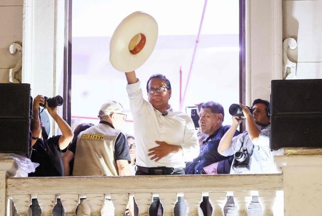 Peru's presidential candidate Roberto Sanchez, for the Juntos por el Peru party, raises his hat as he gives a speech following the first results of the presidential election runoff in Lima on June 7, 2026. Voting stations closed on June 7, 2026 in Peru's presidential election, with exit polls showing four-time candidate Keiko Fujimori with the slenderest of leads over her leftist rival Roberto Sanchez. (Photo by Connie FRANCE / AFP)
