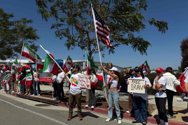 People wave US and pre-revolutionary Iranian flags as they protest the Iranian regime outside of Los Angeles Stadium (temporarly renamed from SoFi Stadium) in Inglewood, California, on June 7, 2026, ahead of the start of the 2026 FIFA World Cup. Iran are scheduled to open their Group G campaign against New Zealand in Los Angeles on June 15, before facing Belgium in the same city and then Egypt in Seattle. (Photo by Sarah LAI / AFP)