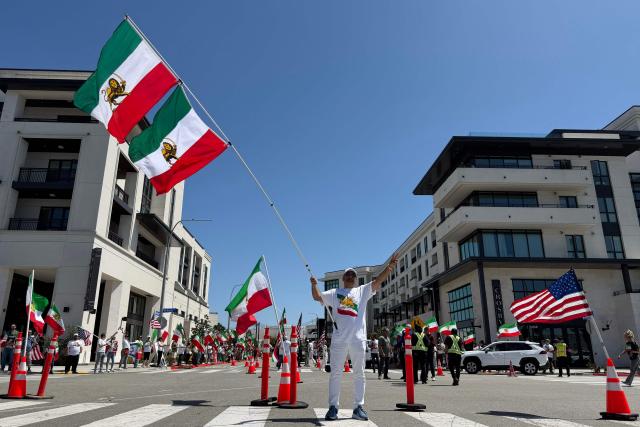 People wave US and pre-revolutionary Iranian flags as they protest the Iranian regime outside of Los Angeles Stadium (temporarly renamed from SoFi Stadium) in Inglewood, California, on June 7, 2026, ahead of the start of the 2026 FIFA World Cup. Iran are scheduled to open their Group G campaign against New Zealand in Los Angeles on June 15, before facing Belgium in the same city and then Egypt in Seattle. (Photo by Sarah LAI / AFP)