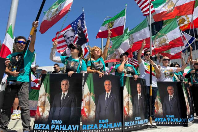 People wave US and pre-revolutionary Iranian flags as they protest the Iranian regime outside of Los Angeles Stadium (temporarly renamed from SoFi Stadium) in Inglewood, California, on June 7, 2026, ahead of the start of the 2026 FIFA World Cup. Iran are scheduled to open their Group G campaign against New Zealand in Los Angeles on June 15, before facing Belgium in the same city and then Egypt in Seattle. (Photo by Sarah LAI / AFP)