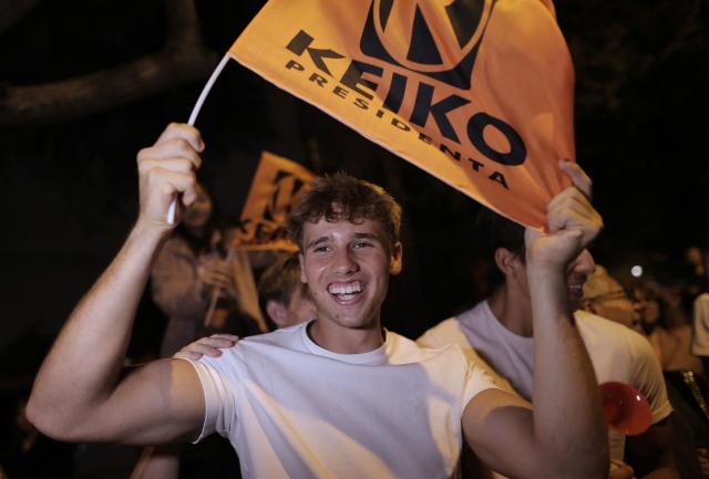 A supporter of Peru's presidential candidate Keiko Fujimori, for the Fuerza Popular party, waves a flag following the first results of the presidential election runoff outside her house in Lima on June 7, 2026. Voting stations closed on June 7, 2026 in Peru's presidential election, with exit polls showing four-time candidate Keiko Fujimori with the slenderest of leads over her leftist rival Roberto Sanchez. (Photo by Anthony Nino de Guzman / AFP)