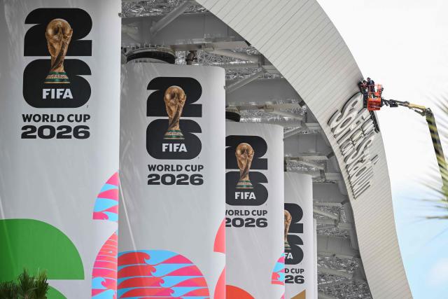 Workers are seen on a crane at Los Angeles Stadium (temporarily renamed from SoFi Stadium) ahead of the 2026 FIFA World Cup in Los Angeles on June 7, 2026. (Photo by Patrick T. Fallon / AFP)