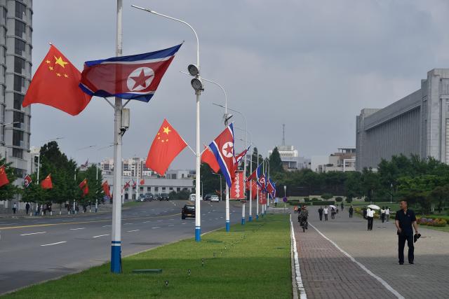 The national flags of North Korea and China are displayed on a street in Pyongyang on June 8, 2026. Chinese President Xi Jinping arrived in Pyongyang on June 8, state news agency Xinhua reported, for his first official visit to North Korea since 2019. (Photo by KIM Won Jin / AFP)