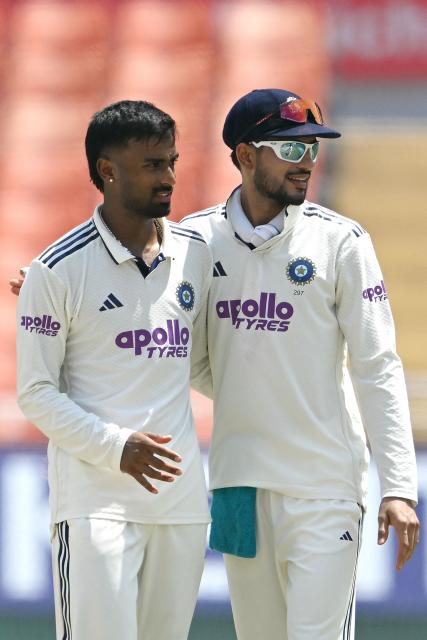 India's Manav Suthar (L) is congratulated by captain Shubhman Gill (R) after taking the wicket of Afghanistan's Mohammad Saleem during the third day of the only Test cricket match between India and Afghanistan at the Maharaja Yadavindra Singh International Cricket Stadium on the outskirts of Chandigarh on June 8, 2026. (Photo by Shammi MEHRA / AFP)