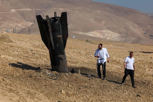 Two men examine a fallen rock half-buried in the ground on the outskirts of Jericho on June 8, 2026, following Iranian and Iran-backed Houthi rebel attacks. Israel and Iran traded fire on June 8, seriously testing a fragile truce and threating hopes for a deal to end the Middle East war. (Photo by Ahmad GHARABLI / AFP) / 