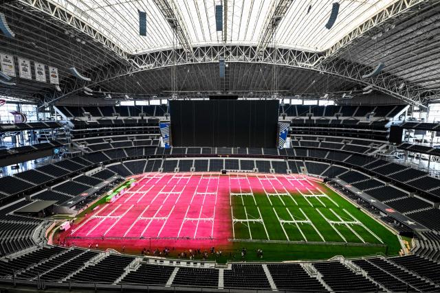 (FILES) Dallas Stadium (temporarily renamed from AT&T Stadium for the 2026 FIFA World Cup) is seen with purple lights illuminating the field to promote grass growth, in Arlington, Texas, on May 14, 2026. Stands, pitch, logos: the stadiums that usually host the NFL have spent several months getting a makeover to comply with FIFA regulations for the World Cup football tournament. (Photo by RONALDO SCHEMIDT / AFP)