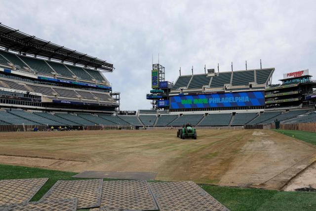 (FILES) Workers prepare the field at Lincoln Financial Field, one of the stadiums hosting the 2026 FIFA World Cup at Lincoln Financial Field in Philadelphia, on April 28, 2026. Stands, pitch, logos: the stadiums that usually host the NFL have spent several months getting a makeover to comply with FIFA regulations for the World Cup football tournament. (Photo by ANGELA WEISS / AFP)