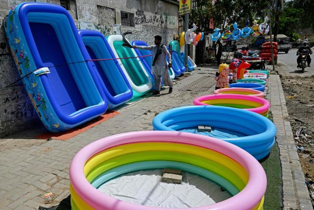 A vendor sells inflatable swimming pools along a street on a hot summer day in Karachi on June 8, 2026. (Photo by Rizwan TABASSUM / AFP)