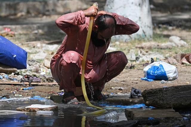 A man cools off on a hot summer day at a garbage-strewn park in Karachi on June 8, 2026. (Photo by Rizwan TABASSUM / AFP)