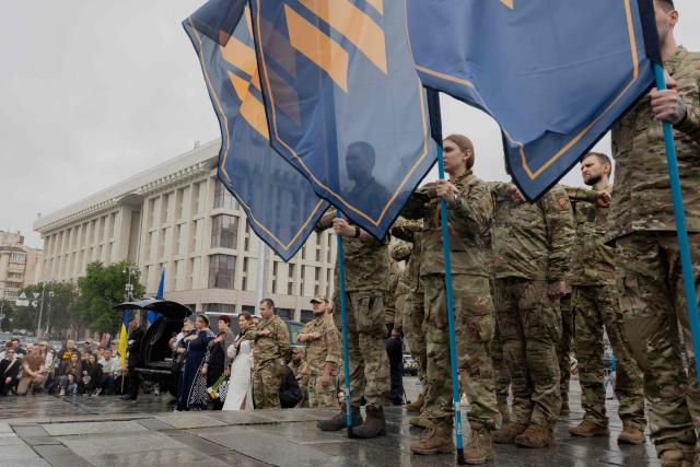 Mourners stand during the funeral ceremony of Yaroslav Varnak, 23 years old a serviceman who was killed in action in Kyiv on June 8, 2026, amid the Russian invasion of Ukraine. (Photo by Tetiana DZHAFAROVA / AFP)