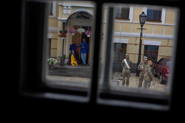 Ukrainian soldiers stand in the street with a trumpet and a tambourine during the funeral ceremony of Yaroslav Varnak, a 23 years old serviceman who was killed in action in Kyiv on June 8, 2026, amid the Russian invasion of Ukraine. (Photo by Tetiana DZHAFAROVA / AFP)